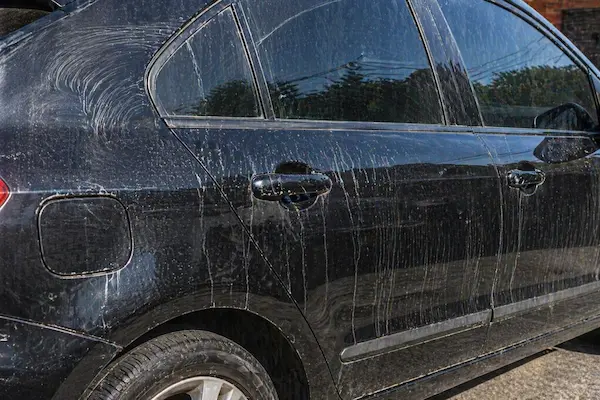 Auto con vetas y marcas de secado visibles sobre la pintura